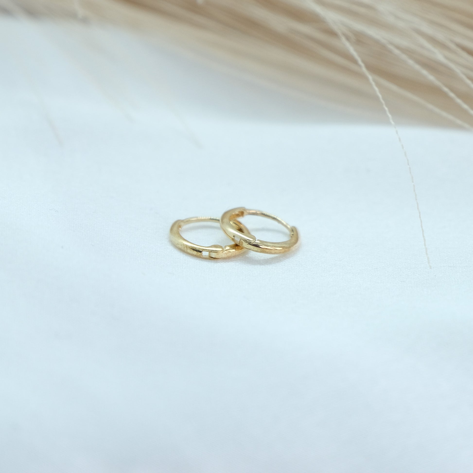 9ct Gold Classic Huggies featuring a sleek and timeless design, perfect for everyday elegance. These versatile earrings add a touch of sophistication to any outfit, suitable for both casual and formal occasions.